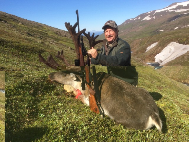 Michael Jaicomo við bráð sína í Þverárgili, ef vel er að gáð sést Tangi, þorpið á Vopnafirði yfir hornagarðinn á tarfinum.