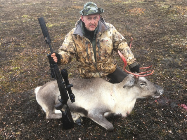 Jóh. Óskar við kúna í rigningunni.